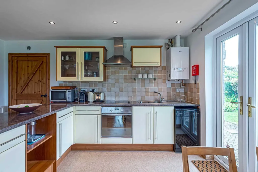 A full view of the kitchen facilities at Fig Tree Cottage, including the oven, hob, sink and microwave