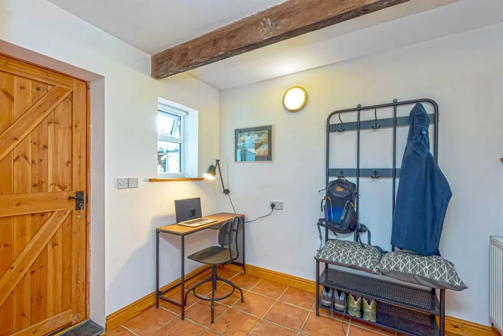 The entrance hall at Laurel Cottage with a coat rack, shoe storage and a convenient work desk