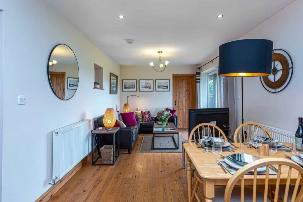 Conwy Valley Getaway | LAUREL COTTAGE LIVING AREA KITCHEN TOWARDS LOUNGE The open-plan living space at Laurel Cottage, seen from the kitchen, showing the dining table and lounge