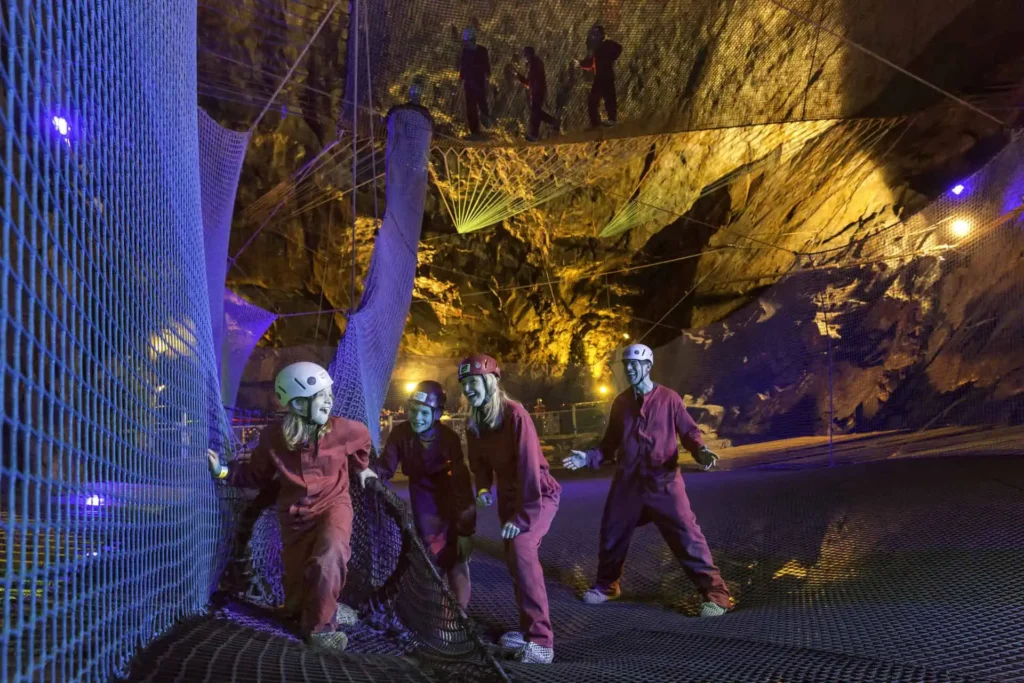 Family having fun in the underground caverns of bounce below at Zip World, Llechwedd
