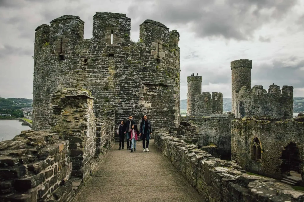 Conwy Valley Getaway | conwycastle grey day Family of four walking along the stone battlements of Conwy Castle on a moody day