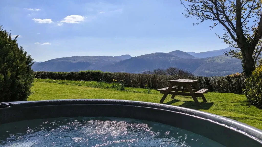View of the Eryri (Snowdonia) mountain range from the bubbling hot tub at the holiday cottage on a sunny day