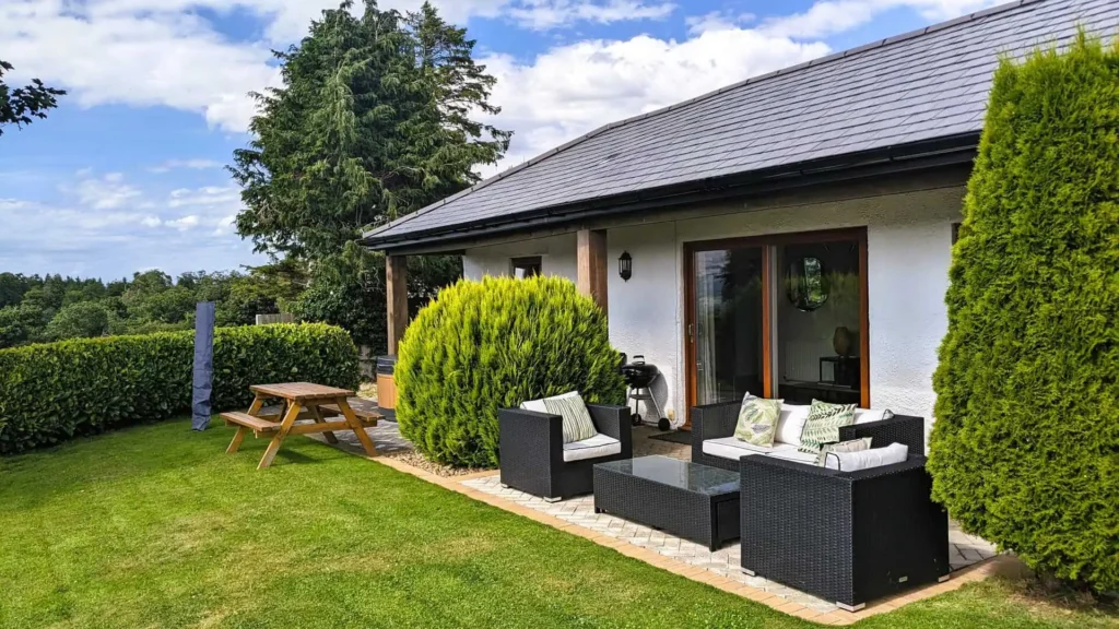 Conwy Valley Getaway | patio outside laurel cottage The comfortable outdoor patio furniture and picnic table in the private garden of Laurel Cottage
