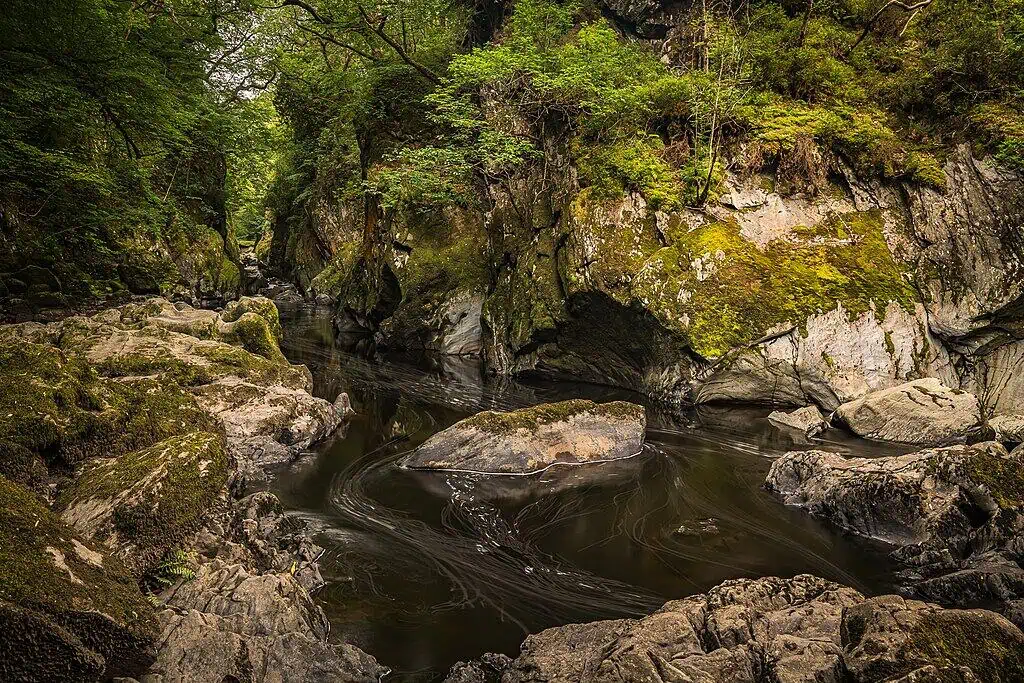 Conwy Valley Getaway | 1024px Fairy Glen Near Betws Y Coed geograph.org .uk 6934726 The rocky, moss-covered river gorge of Fairy Glen in Betws-y-Coed, North Wales