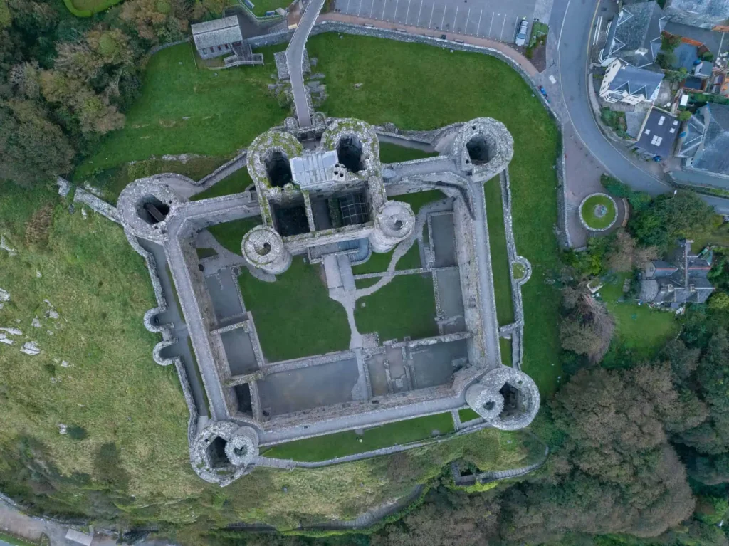 Conwy Valley Getaway | 35807 harlech castle gwynedd web optimised 1920px Aerial view looking directly down on Harlech Castle, clearly showing its concentric 'walls within walls' design, the massive gatehouse on one side, and its dramatic position on a rock cliff