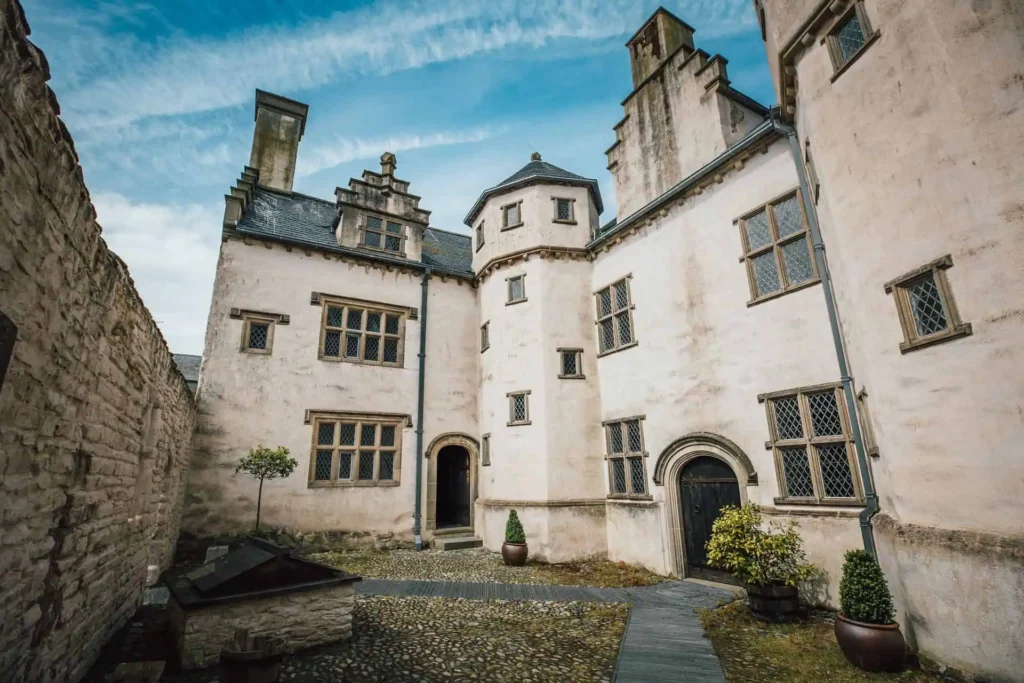 Conwy Valley Getaway | 732791 plasmawr 129 web optimised 1920px The impressive stone facade of Plas Mawr, a well-preserved Elizabethan townhouse in Conwy, showing its arched doorways and small, leaded windows.