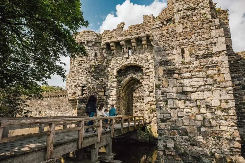 Conwy Valley Getaway | 732314 beaumariscastle 27 web optimised 1920px A family crossing the wooden bridge toward the main entrance of Beaumaris Castle, surrounded by the castle’s moat and medieval walls