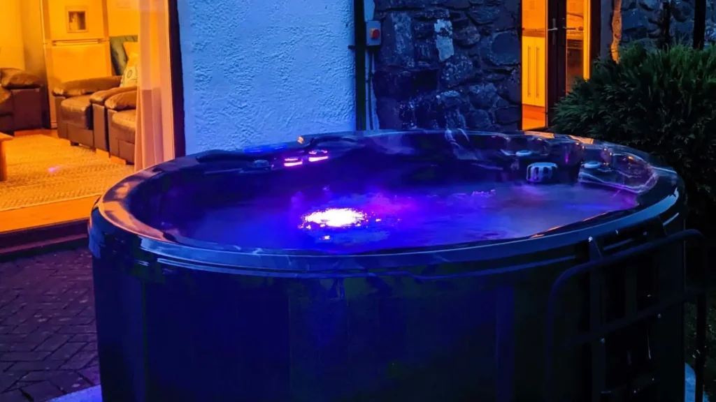 A steaming private hot tub at a cosy winter getaway cottage in the Conwy Valley