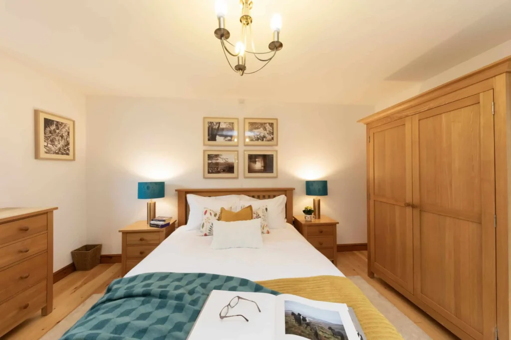 Fig Tree master bedroom with king-size bed, teal lamps and gallery prints above headboard
