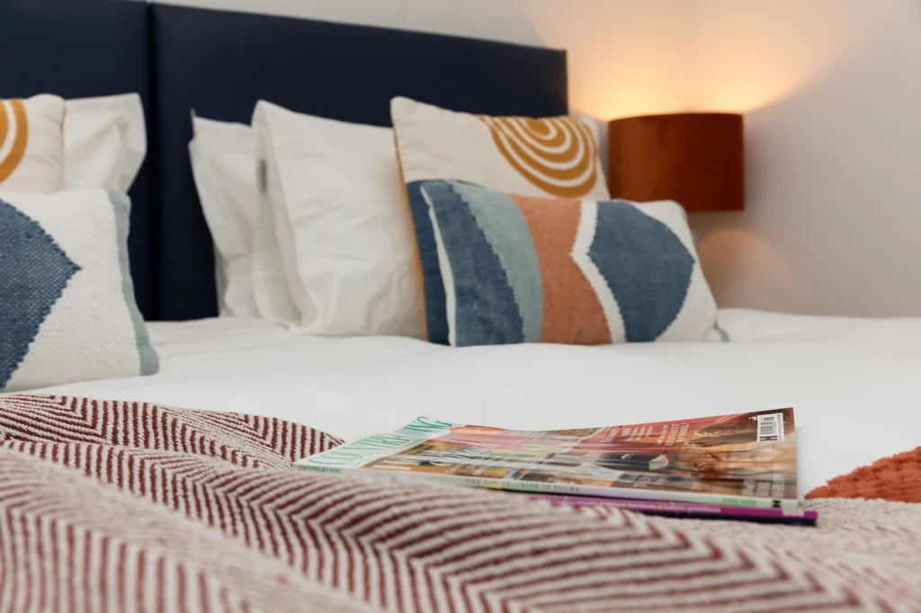 Fig Tree secondary bedroom with magazines and throw, low angle