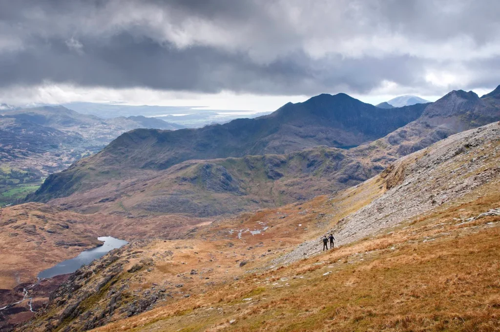 Conwy Valley Getaway | 48232 nvw c73 1011 0391 web optimised 1920px Two people in the distance hiking in the majestic mountains of Eryri